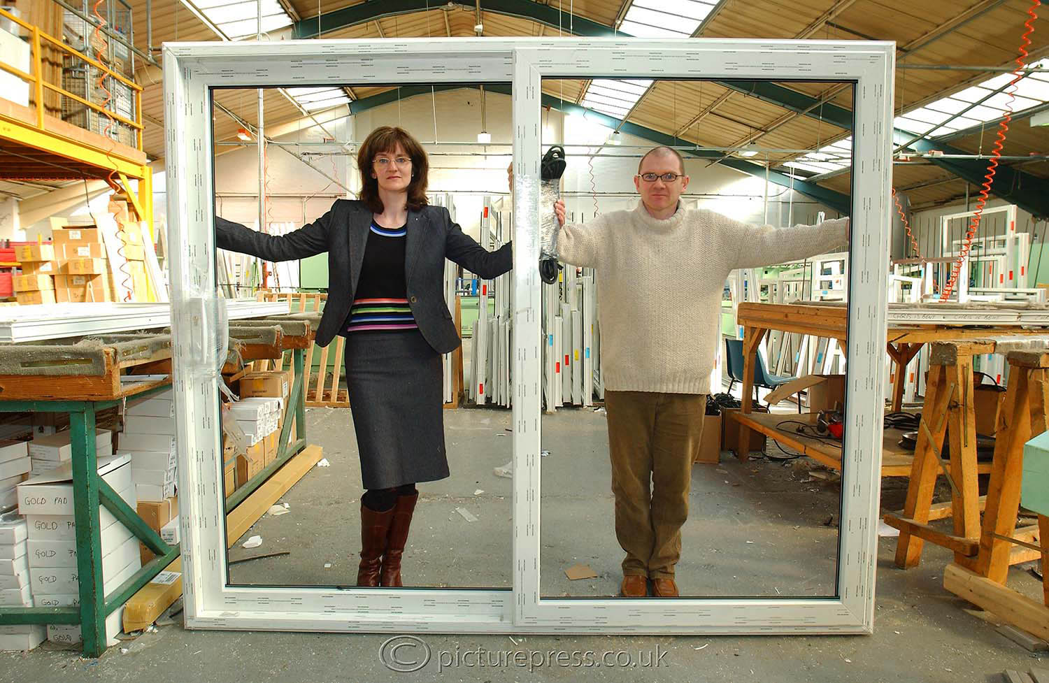 The Armstrongs  holding a large double glazed window frame in the U fit window frame factory in coventry.  image taken  for the telegraph newspaper magazine. by mike kelly  photographer picturepress. For feature about the Armstrongs reality tv show made by bbc tv.