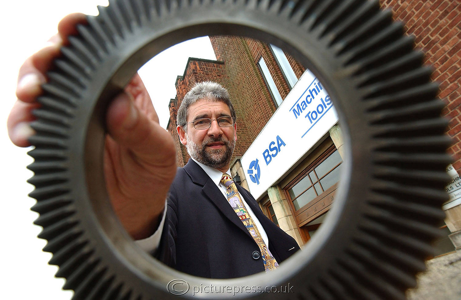 managing director of bsa machine tools with product outside factory in birmingham.  image produced for news paper story. by picturepress photography