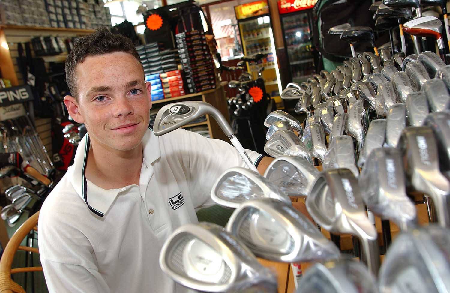 man with golf clubs in golf shop.  image taken for magazine feature. by picturepress  photography birmingham