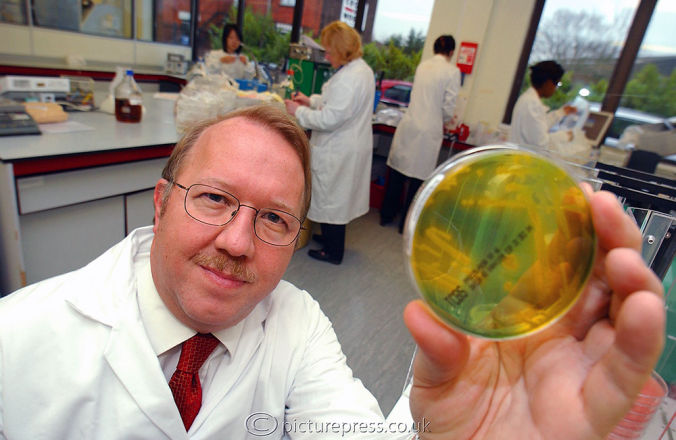 scientist in lab holding culture glass sample taken for aston univeersity in Birmingham